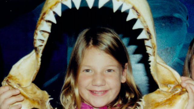 photo of a girl holding a shark's jaw